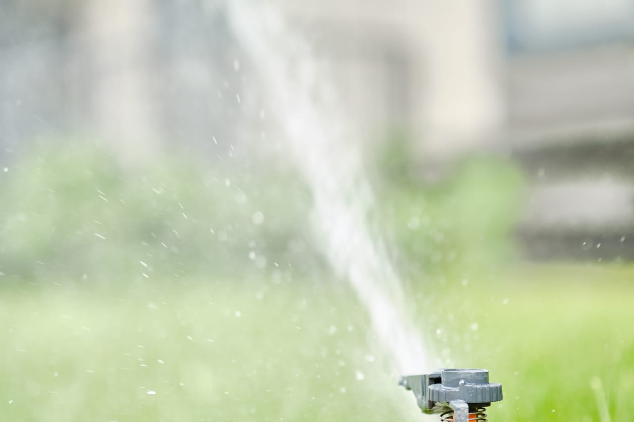 Automatische sproeier in werking op een gazon