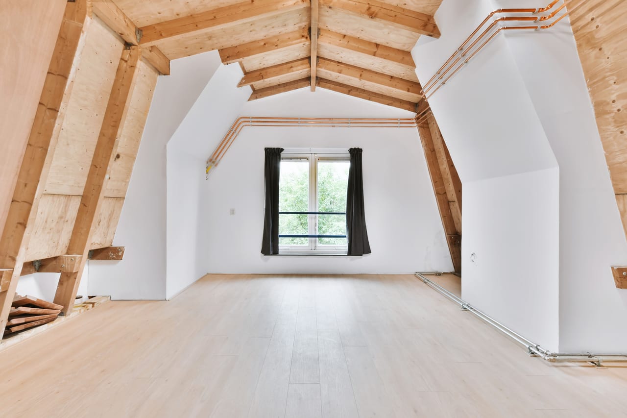 Combles rénovés avec poutres en bois apparentes