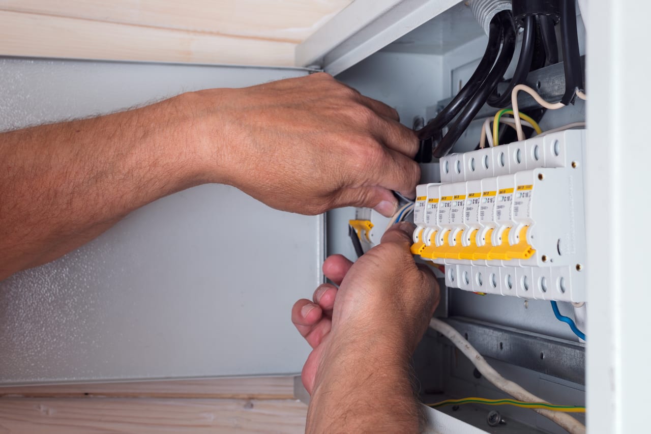 Électricien raccordant un tableau électrique