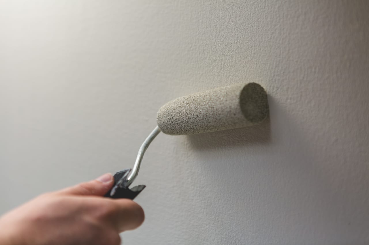 Peintre appliquant une peinture claire au rouleau
